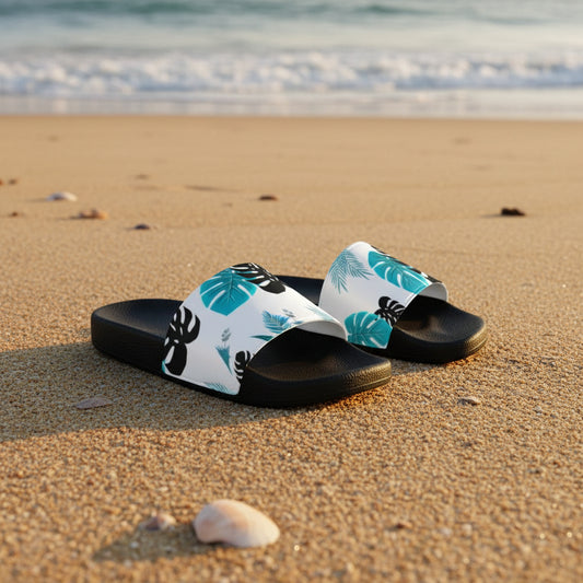 Black slides with white straps featuring blue and green leaf patterns on a white background